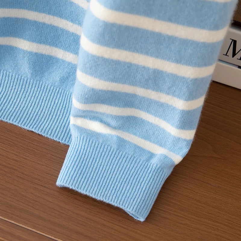 Close-up of a blue sweater with white stripes on a wooden surface
