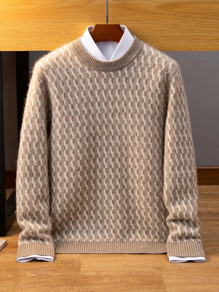 Beige patterned sweater on a hanger against a wooden wall.