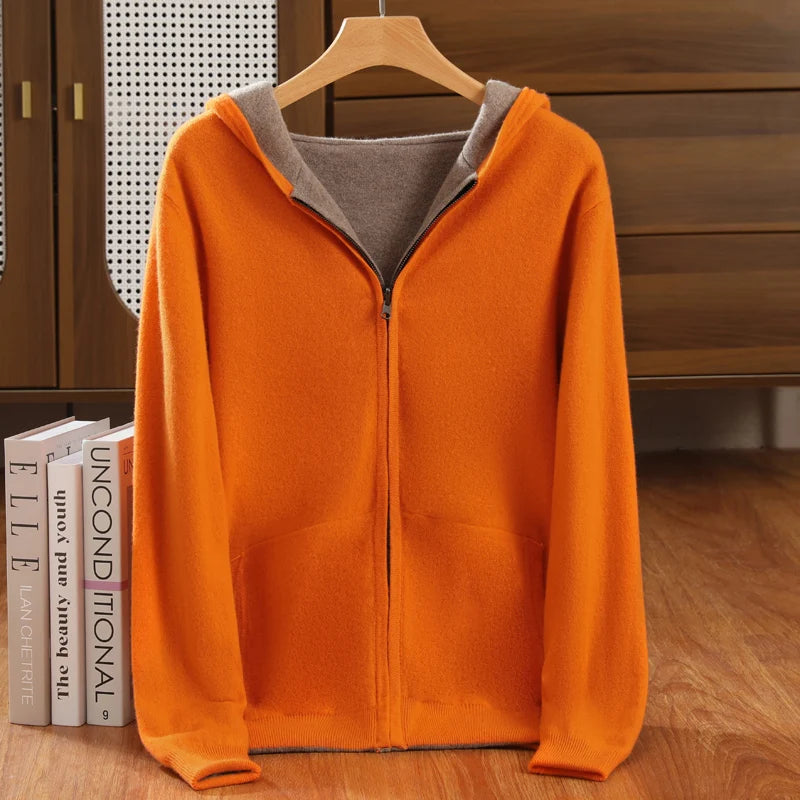 Orange hoodie with gray lining on a wooden hanger against a wooden background