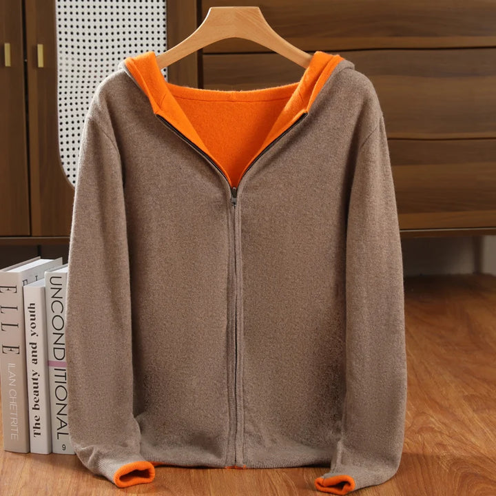 Gray hoodie with orange lining on a hanger against a wooden background