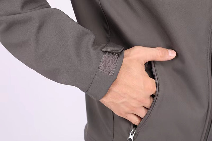 Hand opening a gray jacket zipper on a light gray background