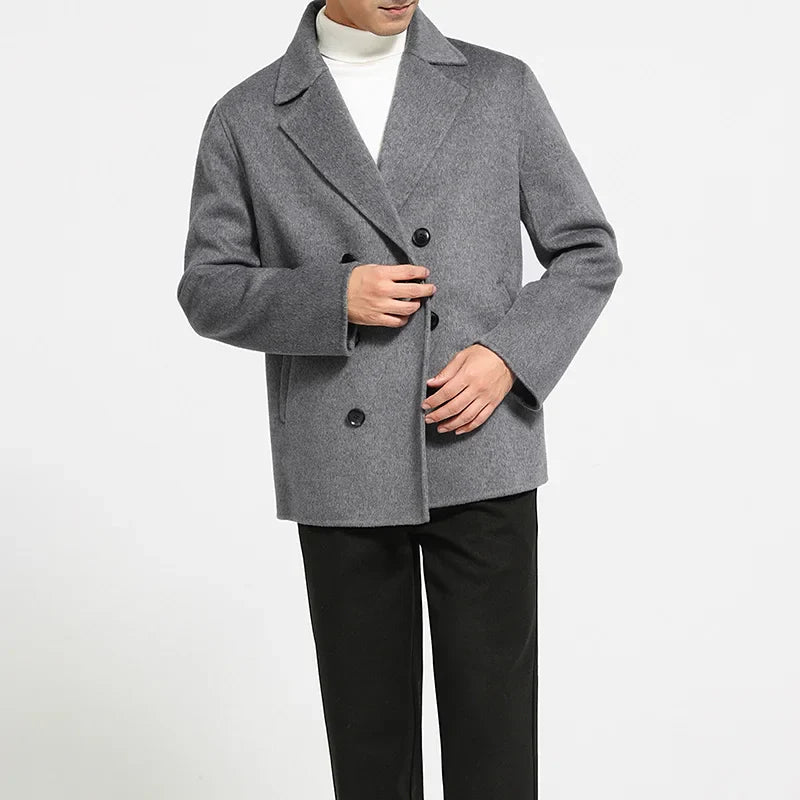 Person wearing a gray coat with black buttons on a white background