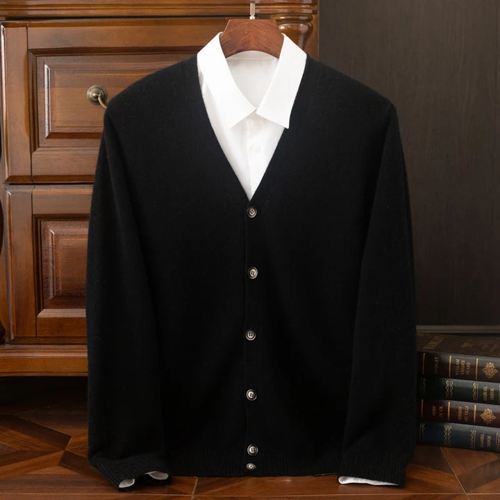 Black cardigan over a white shirt on a wooden hanger against a dark background