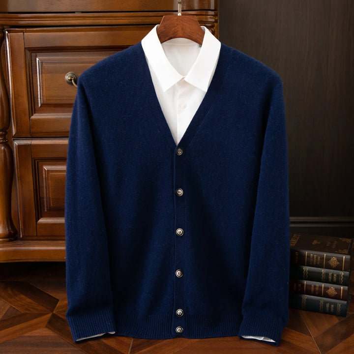 Blue cardigan over a white shirt on a wooden hanger against a dark background