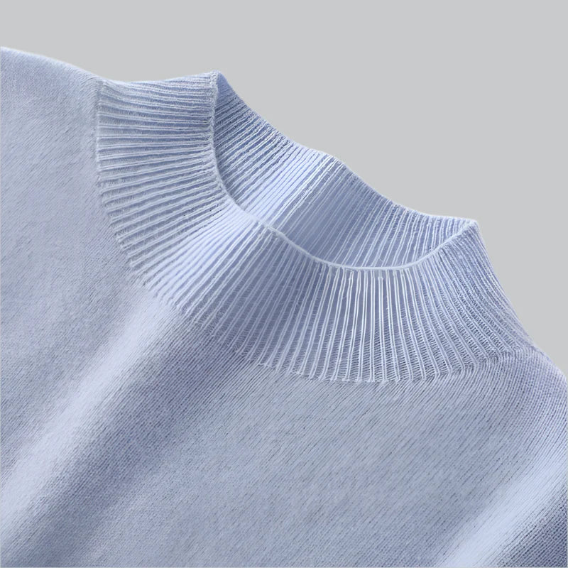 Close-up of a light blue sweater with ribbed neckline on a light gray background
