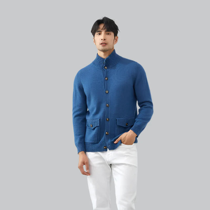 Man wearing a blue knitted cardigan on a gray background