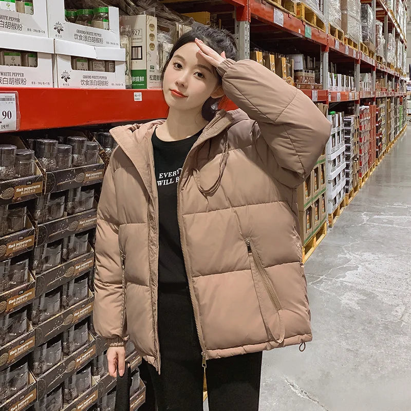 Person wearing a beige puffer jacket in a warehouse setting