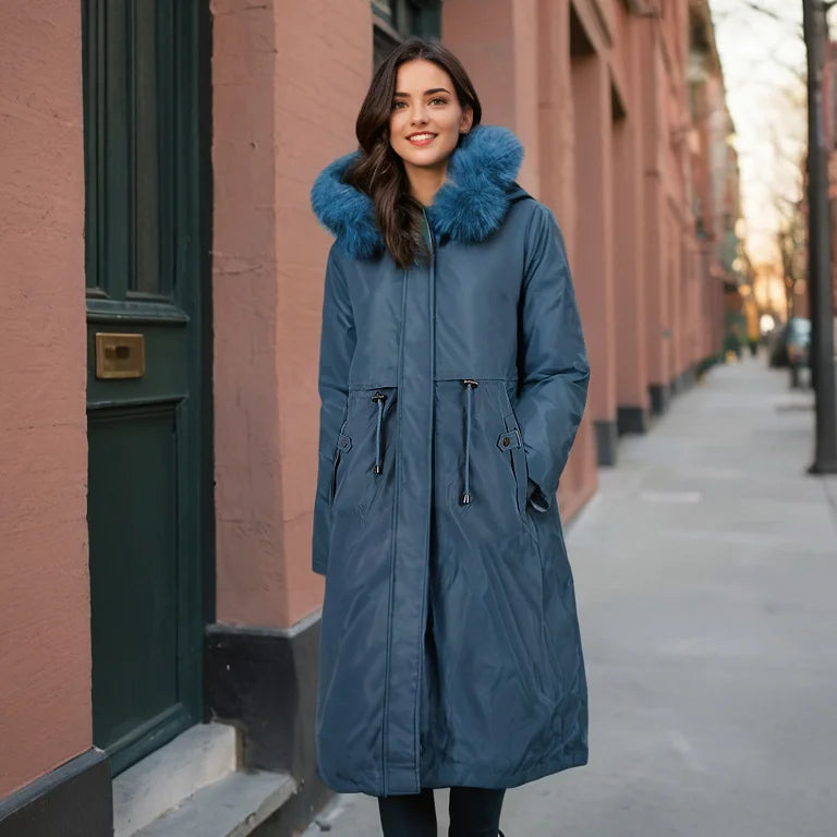 Woman wearing a blue coat with a fur-lined hood on a city street.
