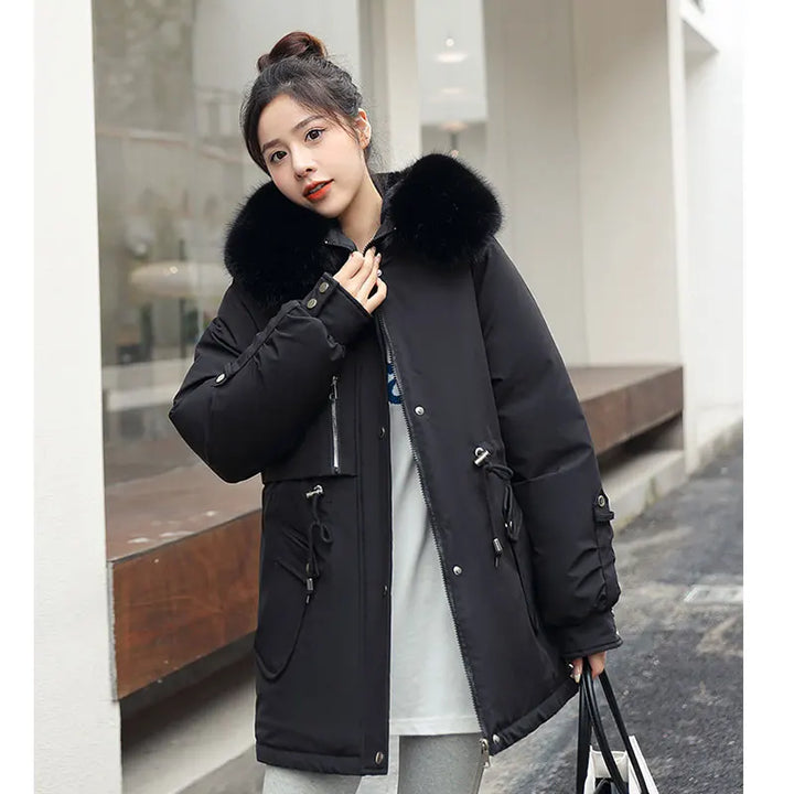 Woman wearing a black winter coat with fur hood in an urban setting