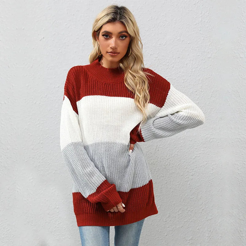 Woman wearing a color-blocked sweater with red, white, and gray sections against a plain background.