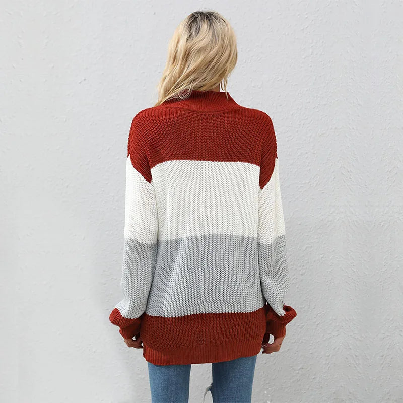 Person wearing a color-blocked sweater with red, white, and gray sections against a plain background.