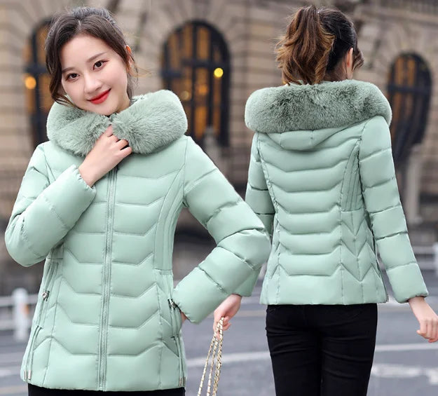 Light green puffer jacket with fur collar worn by a model outdoors.
