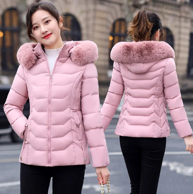 Pink puffer jacket with fur hood worn by a person on a city street.