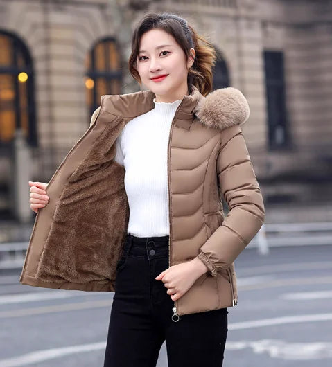 Woman wearing a brown puffer jacket with fur hood in an urban setting
