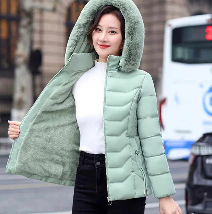 Woman wearing a light green puffer jacket on a city street.
