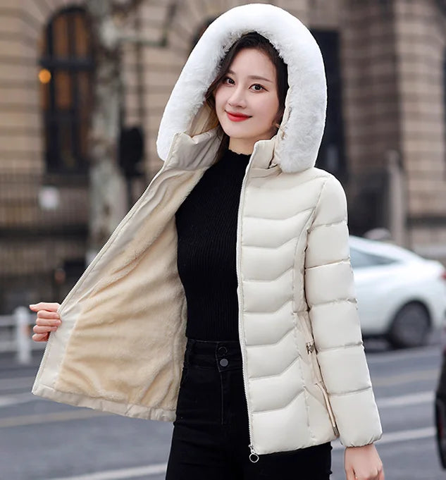 Woman wearing a white hooded puffer jacket on a city street.