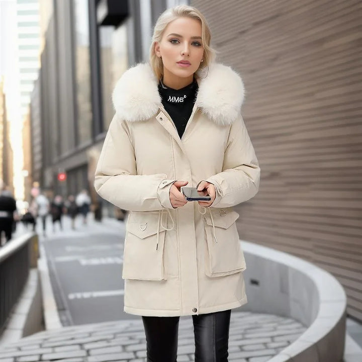 Woman wearing a beige coat with fur collar on a city street