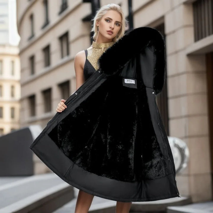 Woman holding a black coat with fur trim in an urban setting