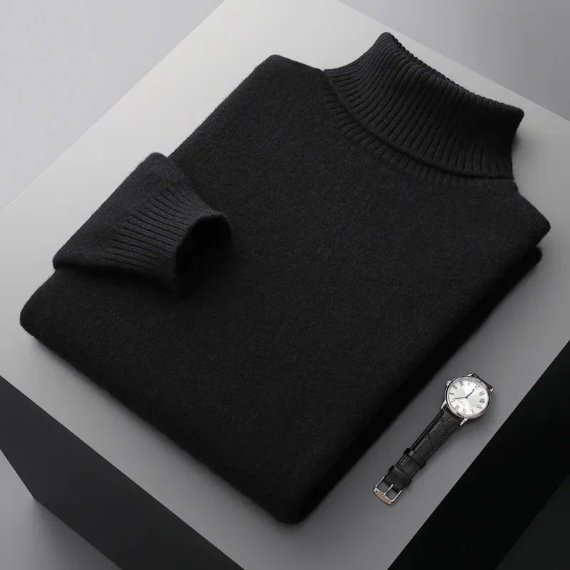 Black turtleneck sweater and watch on a gray surface