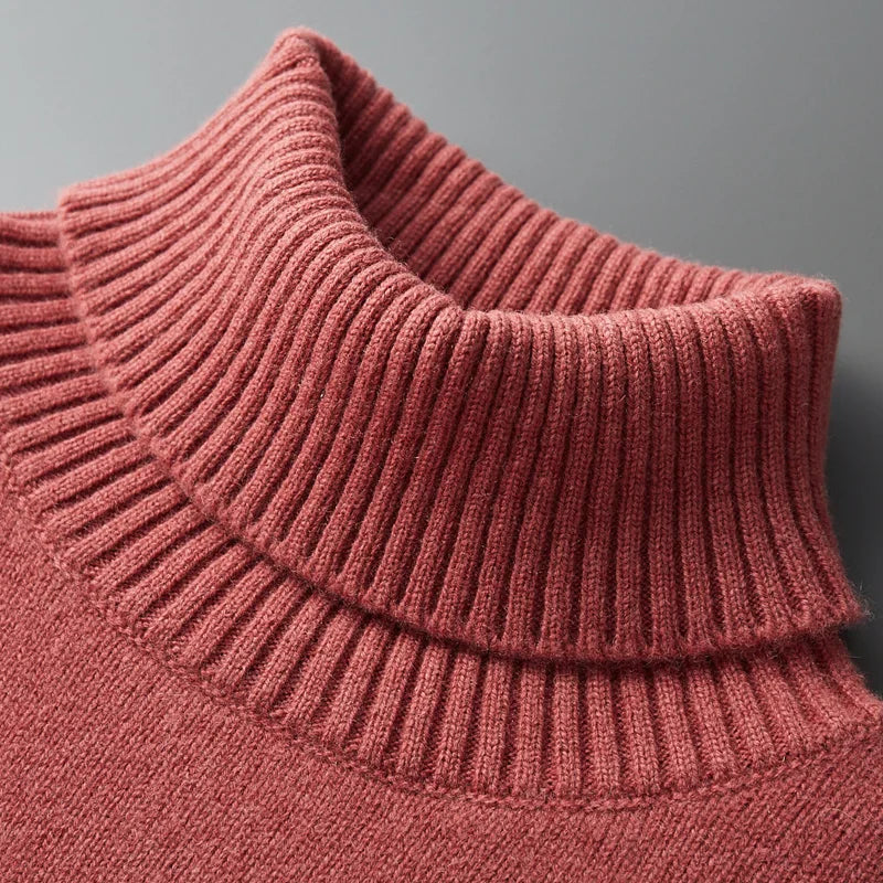 Close-up of a pink knitted sweater with a gray background