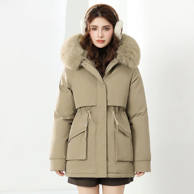 Woman wearing a beige parka with fur hood and white earmuffs on a white background