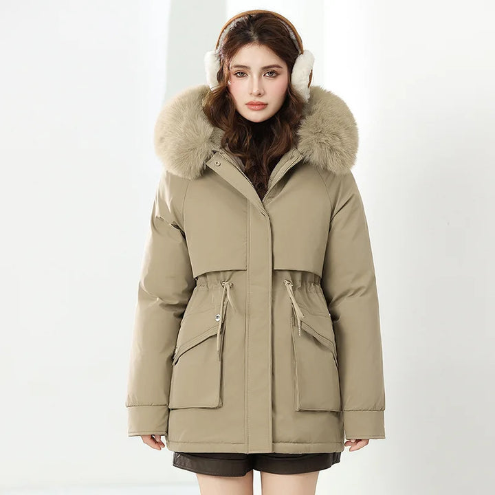 Woman wearing a beige parka with fur hood and white earmuffs on a white background
