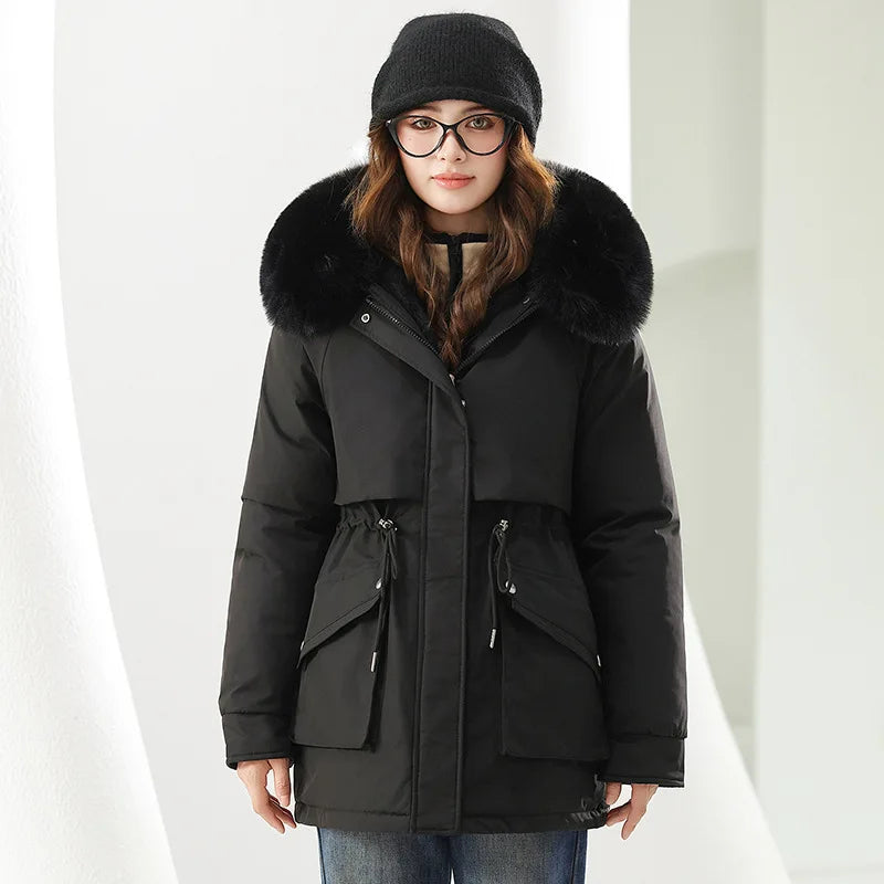 Person wearing a black winter coat with fur hood on a white background