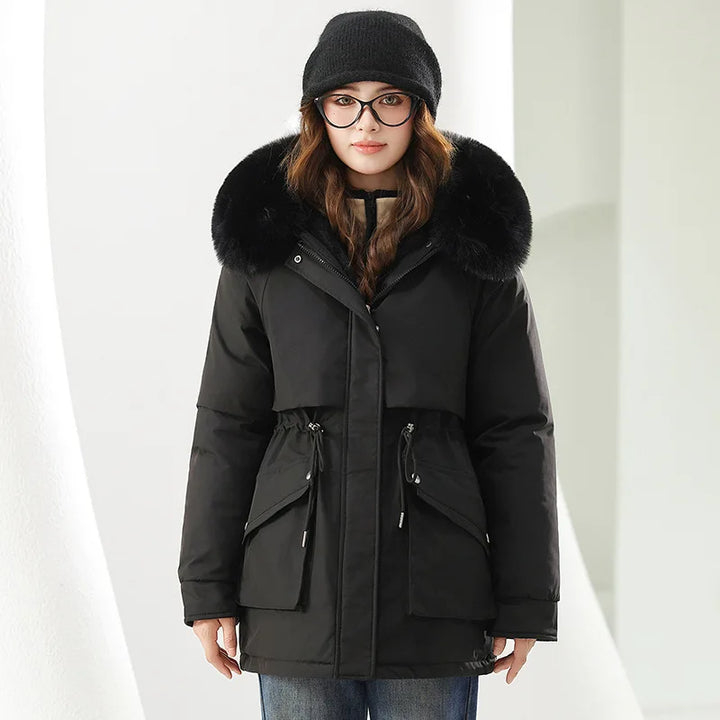 Person wearing a black winter coat with fur hood on a white background