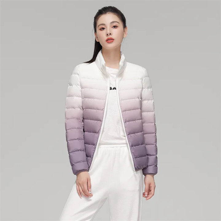 Woman wearing a gradient purple and white puffer jacket on a gray background
