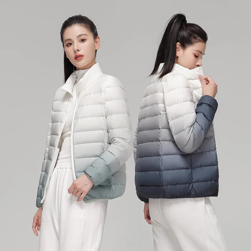 Two women wearing white puffer jackets with gray accents on a plain background