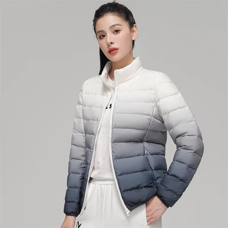 Woman wearing a white and gray gradient puffer jacket on a gray background