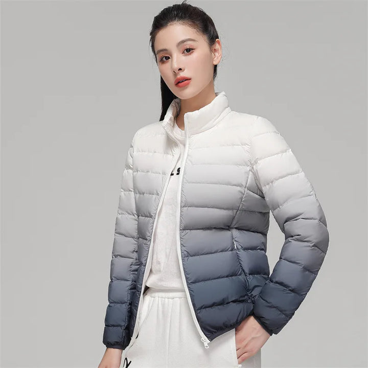 Woman wearing a white and gray gradient puffer jacket on a gray background
