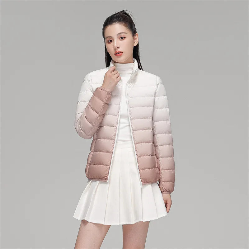 Person wearing a gradient white to pink puffer jacket on a gray background