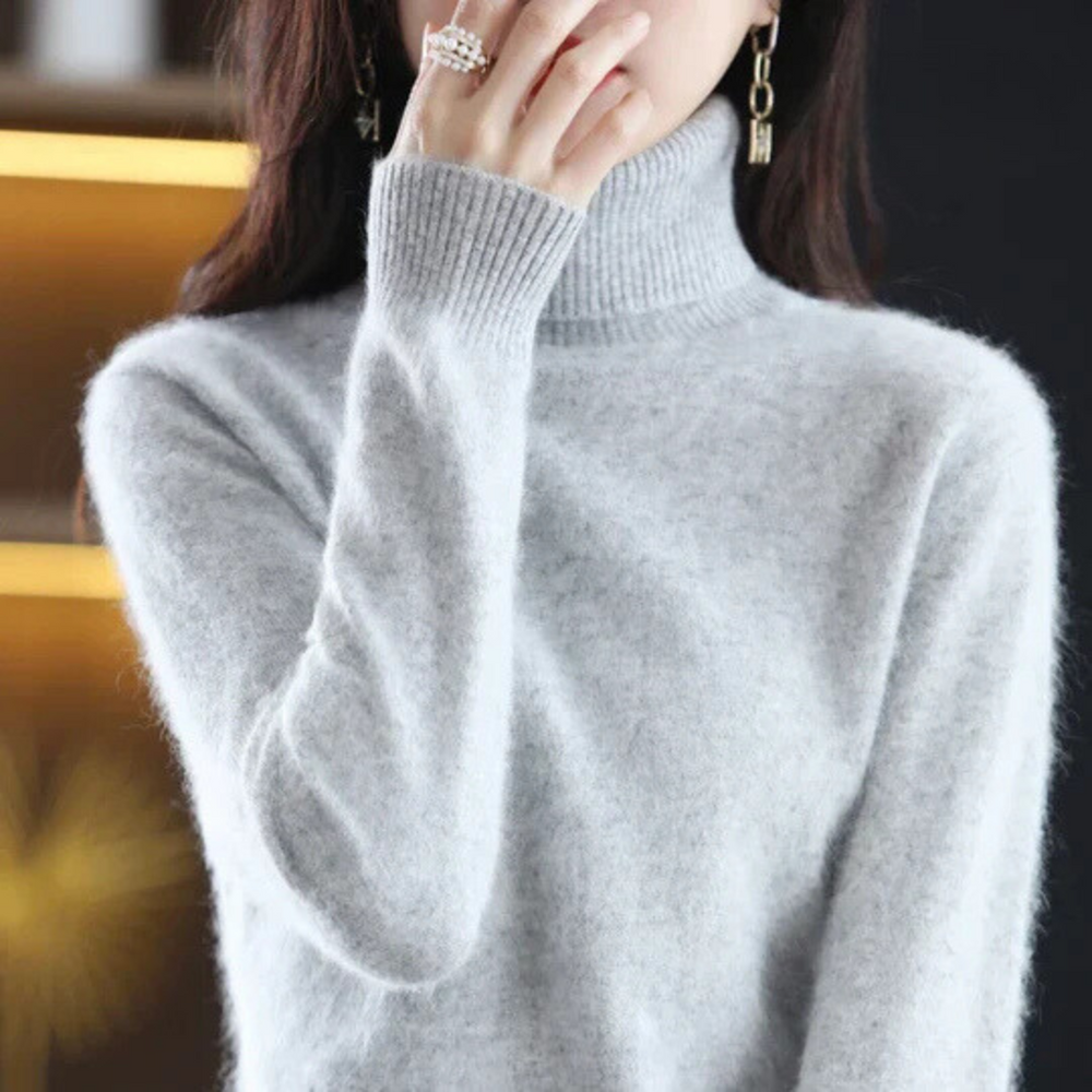 Gray sweater worn by a person with a blurred background