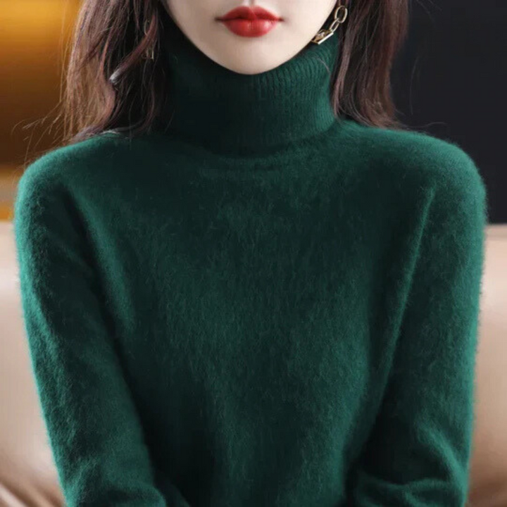 Person wearing a dark green turtleneck sweater with a blurred background