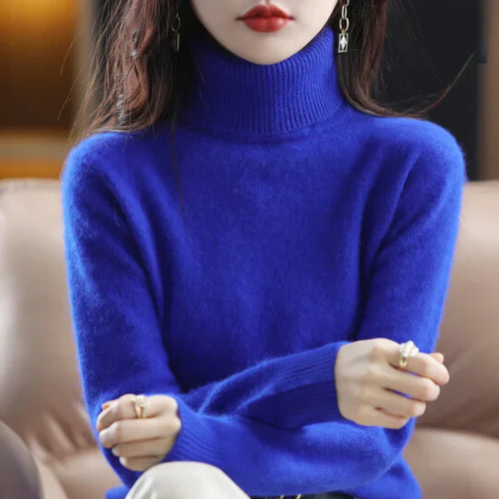 Person wearing a blue turtleneck sweater with a blurred background