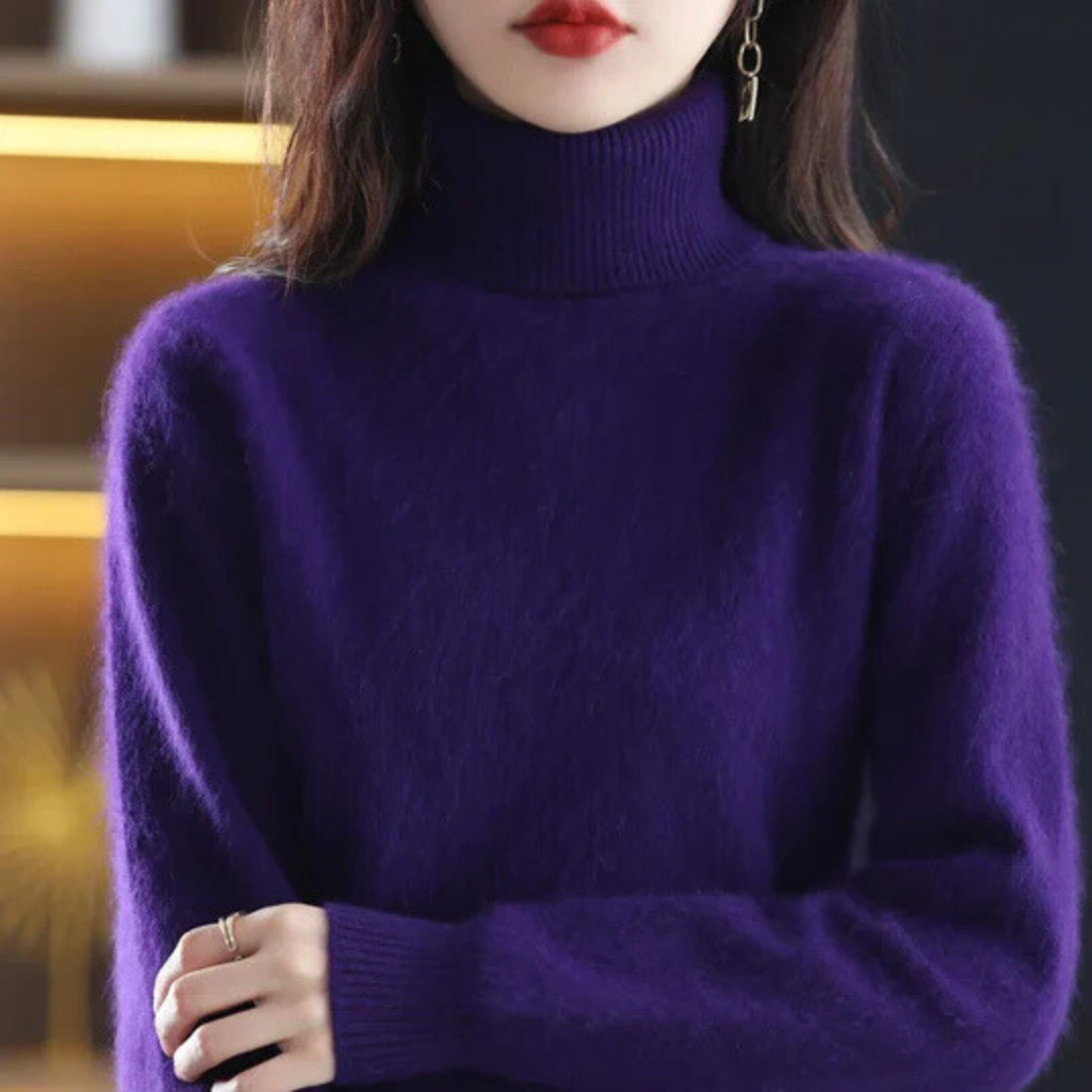 Person wearing a purple turtleneck sweater with a blurred background