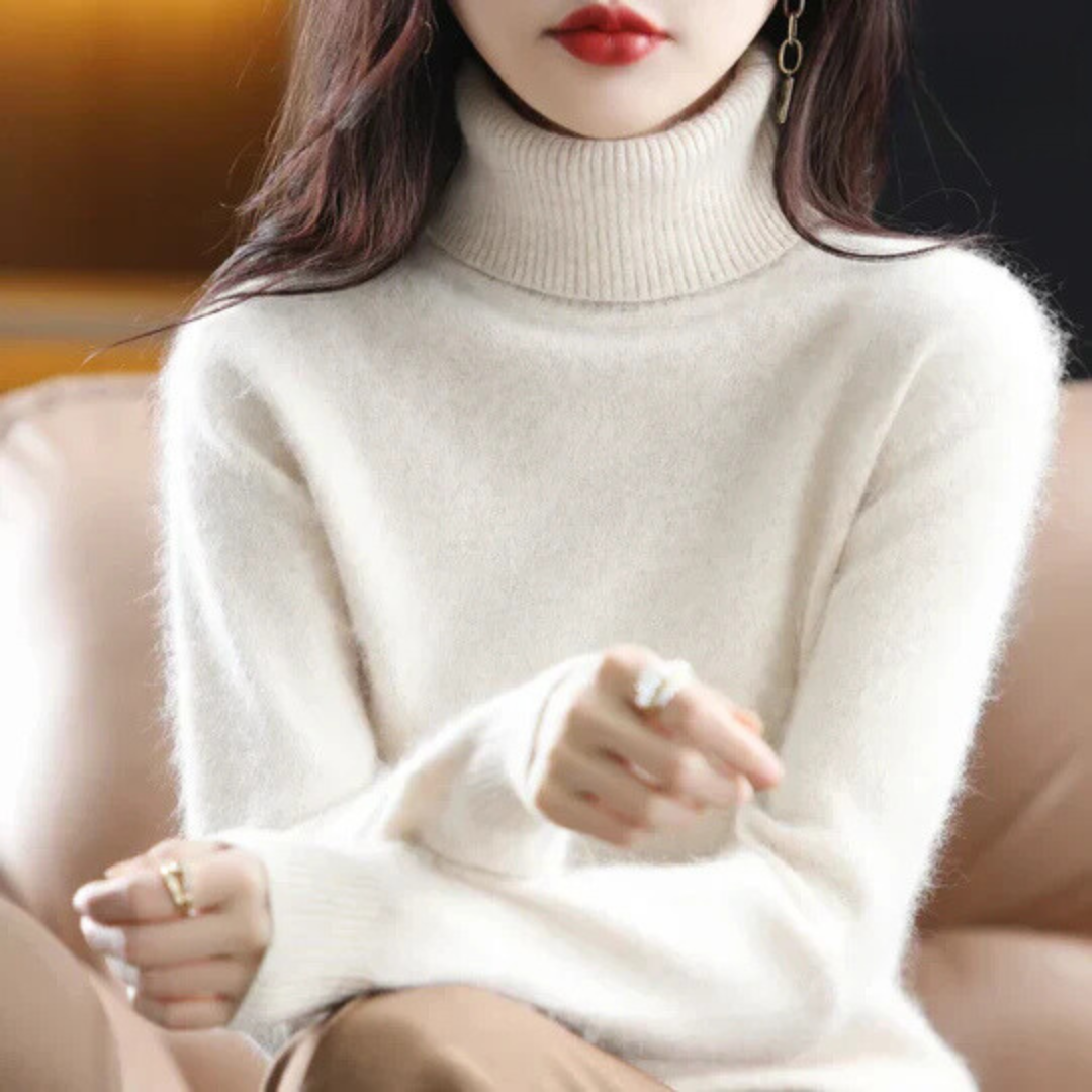 Person wearing a white turtleneck sweater with a blurred background