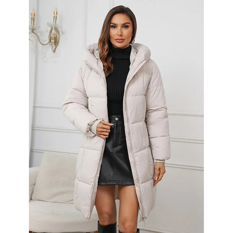 Woman wearing a long beige puffer coat in an indoor setting