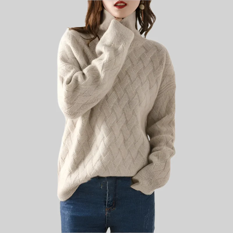 Beige cable knit sweater worn by a person on a plain background