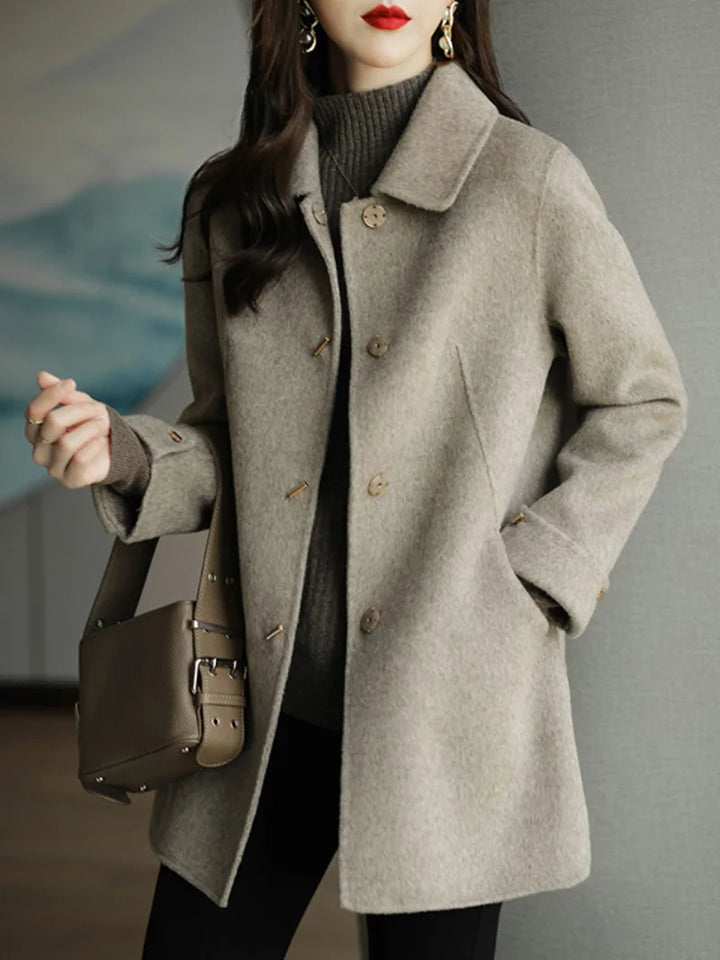 Woman wearing a gray coat with a blurred background