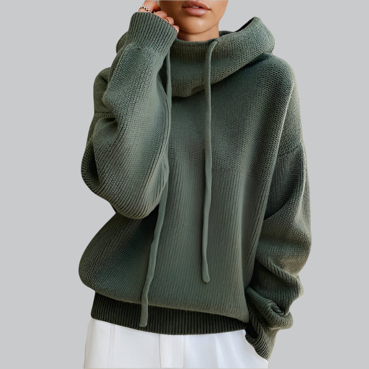 Green knitted hoodie worn by a person on a light gray background