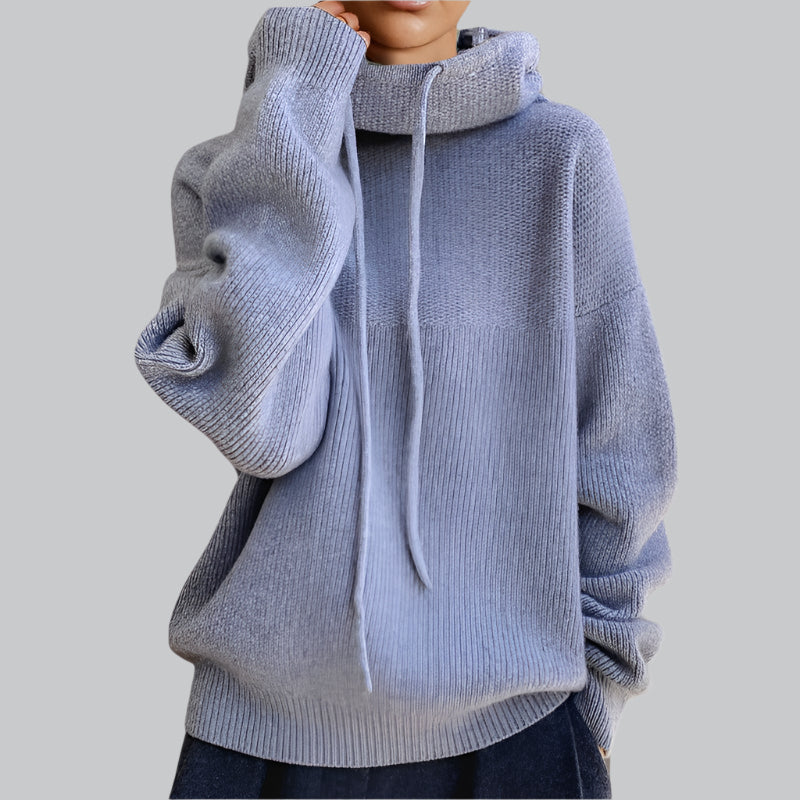 Light blue knitted sweater with a hood on a plain background