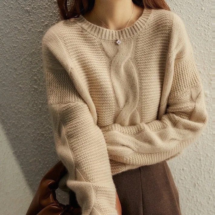 Beige knitted sweater worn by a person against a neutral background